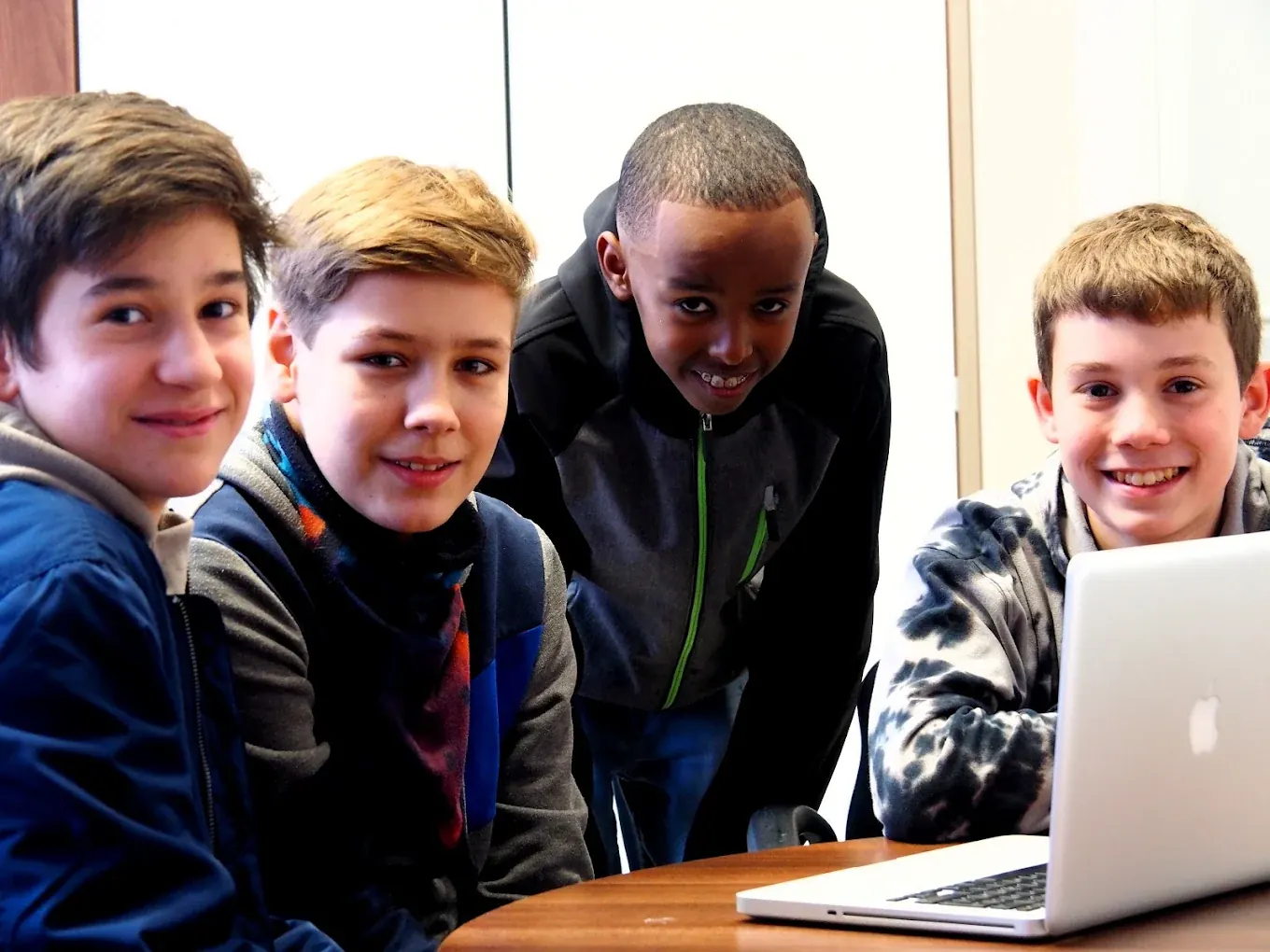 Vier Schüler lachen gemeinsam in die Kamera
