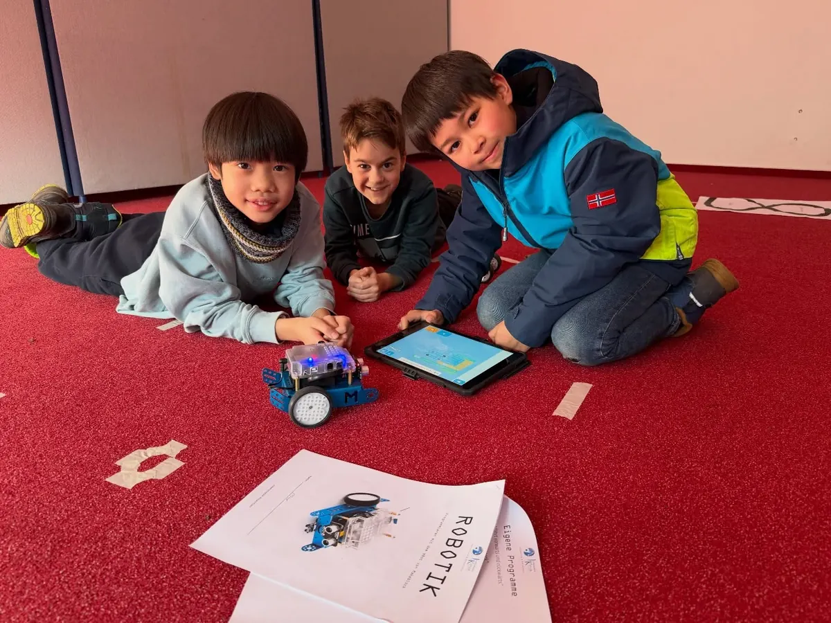 Kinder programmieren einen Roboter mit dem Tablet